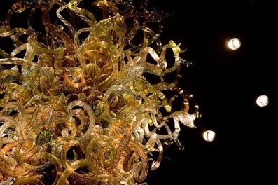 Escultura de cristal soplado iluminada sobre fondo oscuro